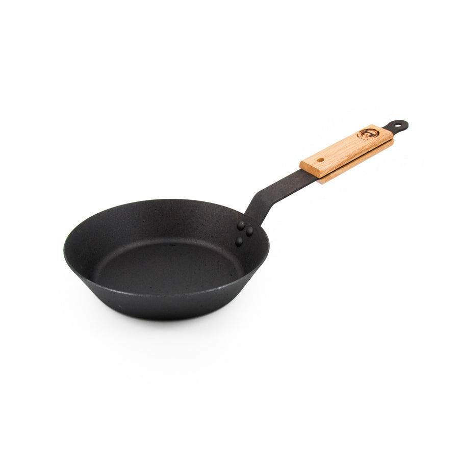 A spun iron frying pan with a wooden handle.